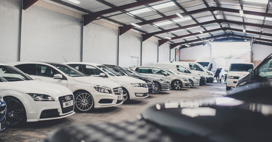 A vehicle showroom with cars and vans lined up