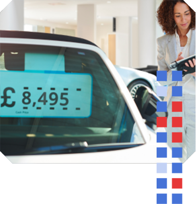 Autotrader Valuations A sales manager standing next to a car with an impartial vehicle price tag