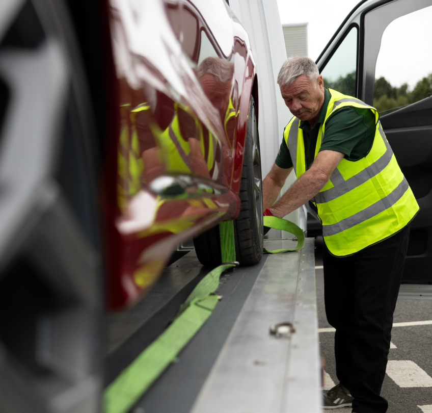 Vehicle Moves A man securing a vehicle on a transporter